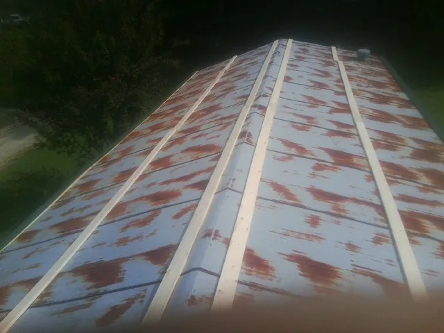 Rusted metal roof panels with new wood purlins before replacement — Storm Damage Roof Repair in Saint Michaels by Roofing Brothers