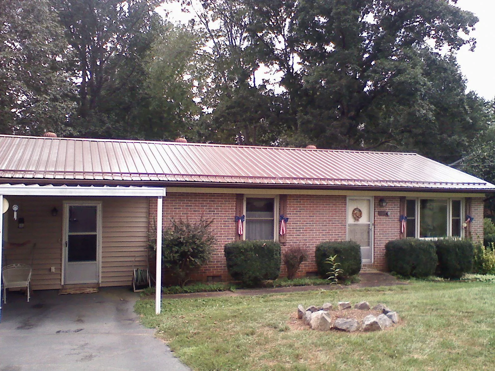 Bronze metal roof and carport on a brick ranch home — Roof Repair work by our crew in Saint Michaels